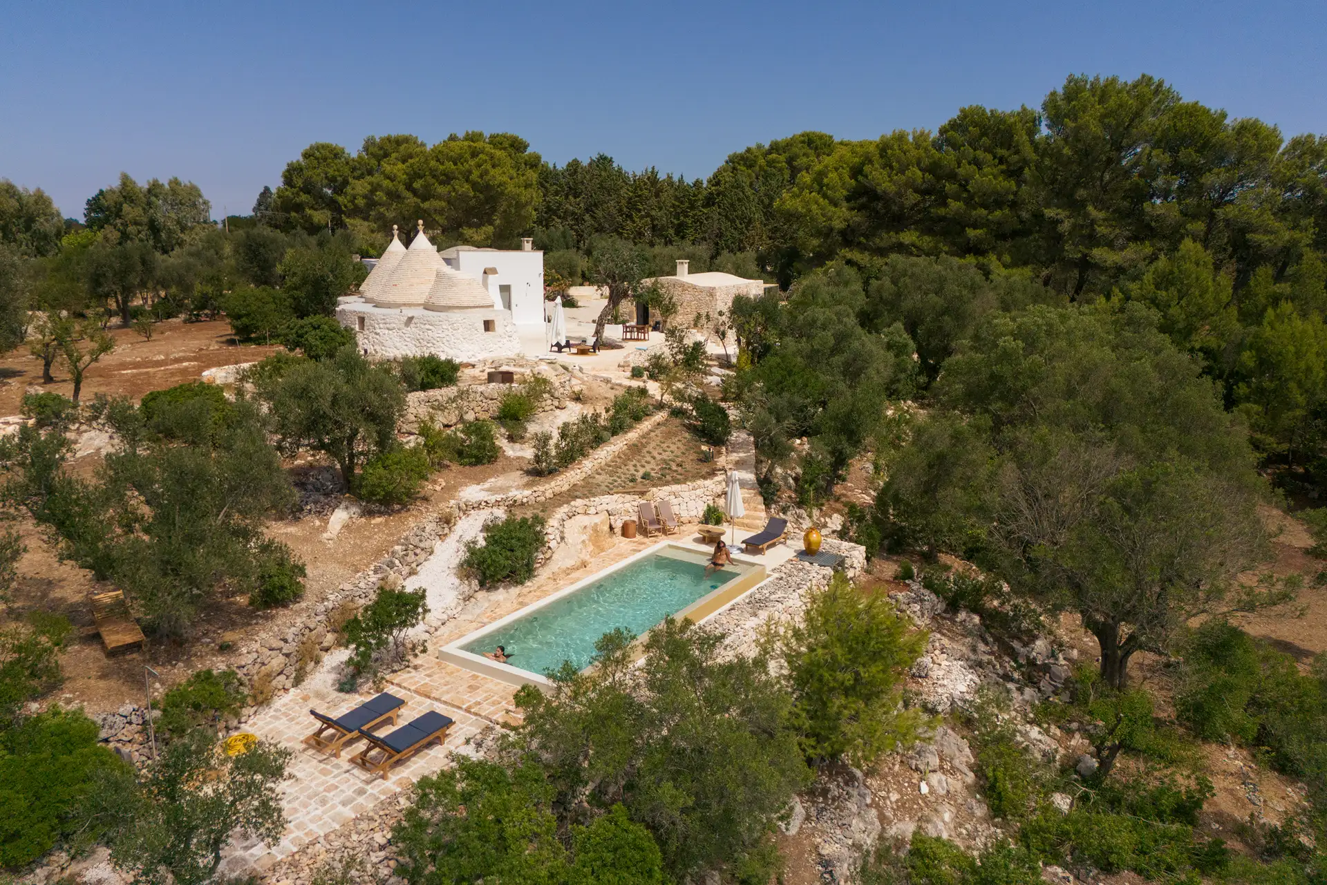Nestled among ancient olive trees, Mediterranean greenery, and the golden glow of Puglia